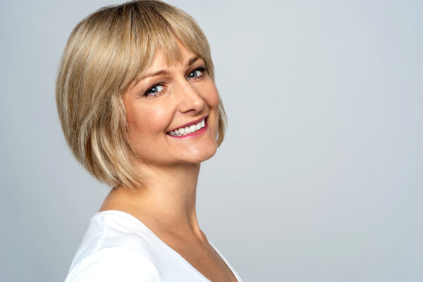 Pretty middle aged lady posing over grey background